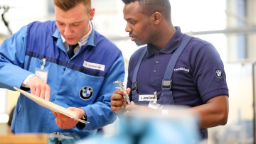 2018 Sachsen, Leipzig: Ausbilder Roy Grambow (l) spricht mit dem Auszubildenden Abdi Jamal Awal im BMW-Werk Leipzig. Das Bundespräsidentenpaar besuchte im Rahmen der Woche der beruflichen Bildung unter dem Motto «Du bildest Zukunft» 