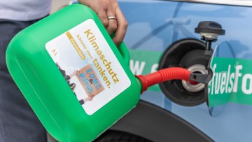 Mann betankt Auto mit E-Fuels 