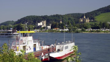 Eine Fähre am Flussufer mit einer Stadt und bewaldeten Hügeln im Hintergrund, Rhein, Andernach, Rheinland-Pfalz, Deutschland