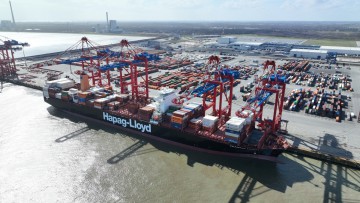 Ein Schiff von Hapag Lloyd wird am Hafen von Kränen mit Containern beladen