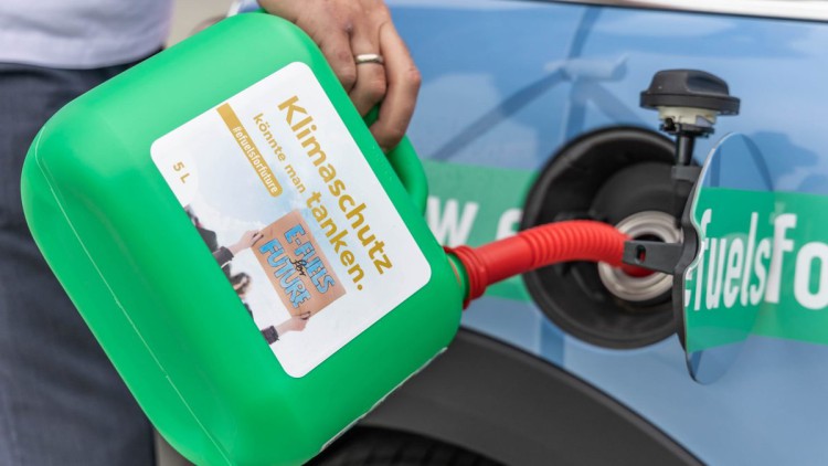 Mann betankt Auto mit E-Fuels 