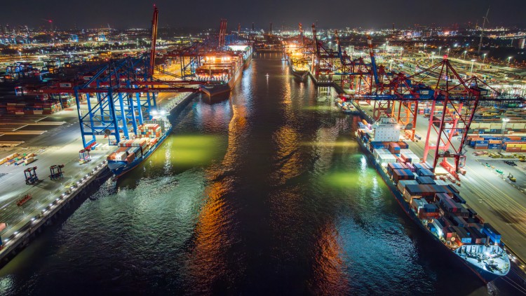 Containerschiffe und Kräne im hamburger Hafen bei Nacht