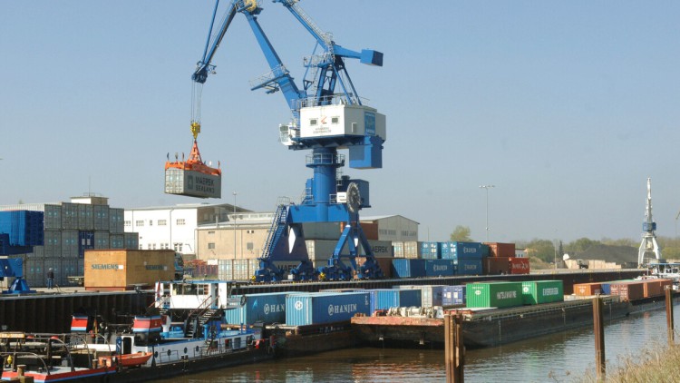 Ein Kran hebt  im Elbhafen Aken Container von einem Prahm