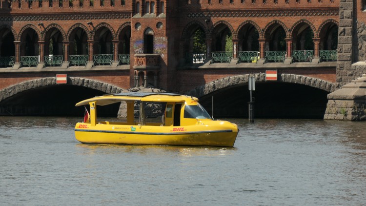 Gelbes Bot vor roter Backsteinbrücke