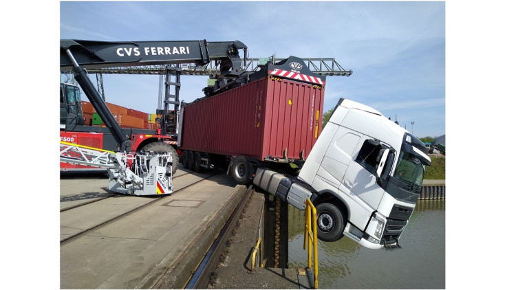 Ein Sattelzug hängt mit der Zugmaschine halb über dem Hafenbecken